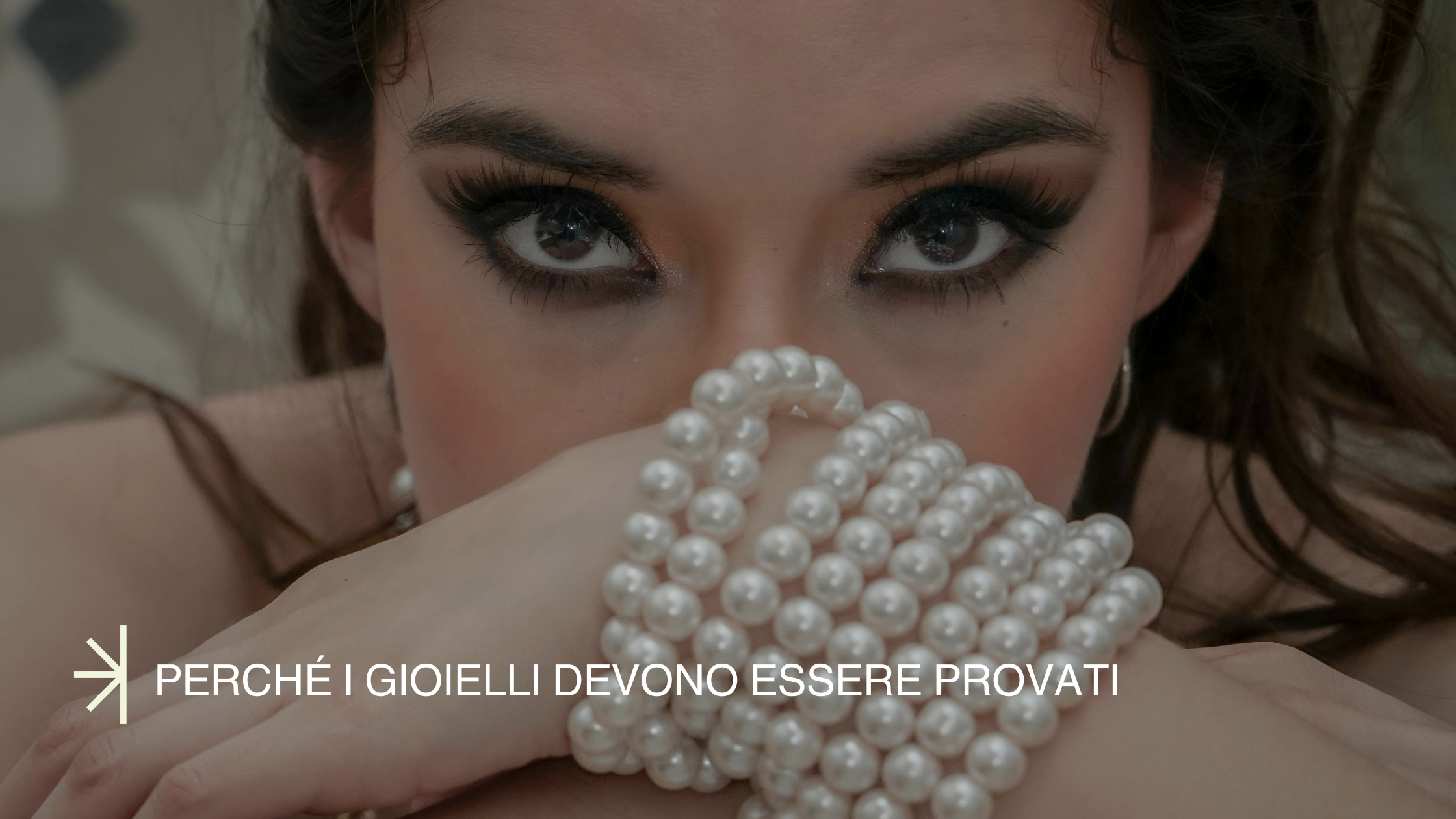 Perché i gioielli devono essere provati. Modella indossa bracciale di perle. Modella ha sguardo magnetico