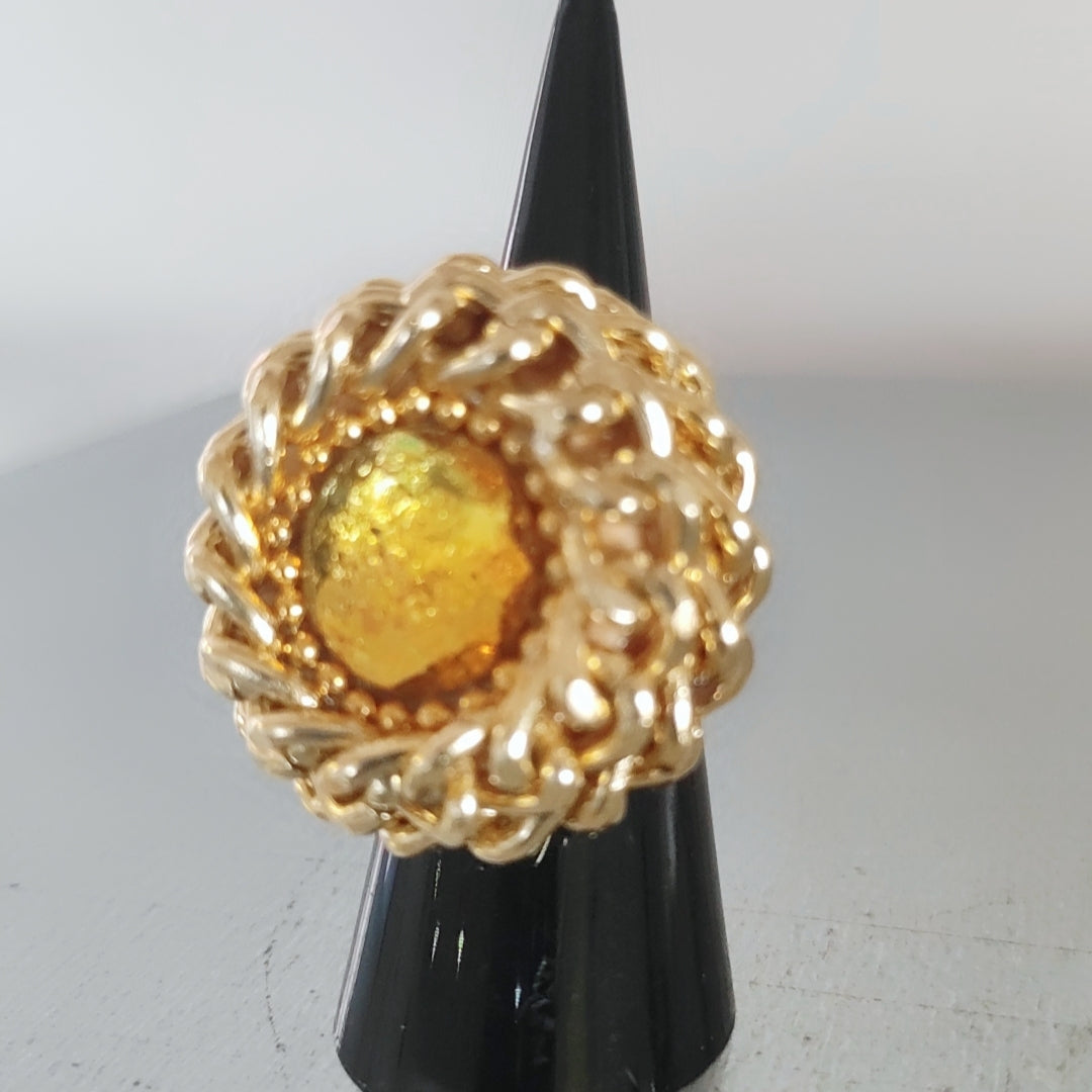 Anello vortice di catena rockabilly con cristallo swarovski colore giallo, su supporto cono nero.