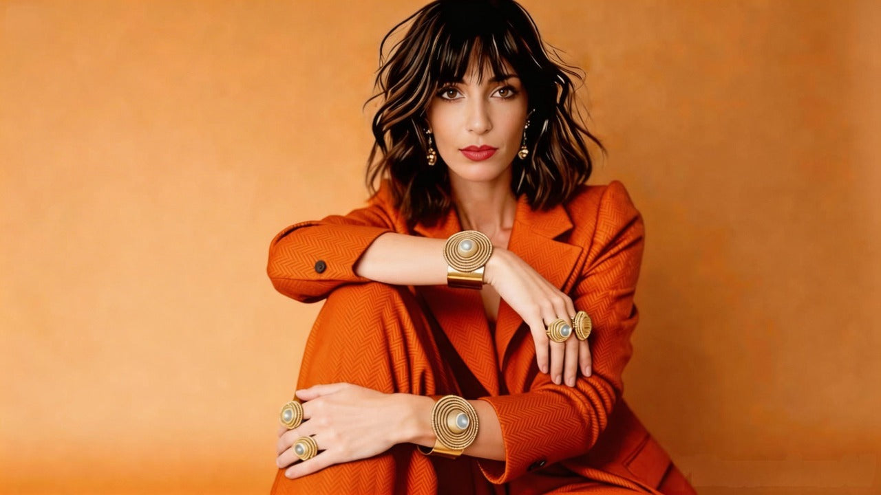 Claudia De Rosa indossa tailleur arancione  e i bracciali e anelli calamita