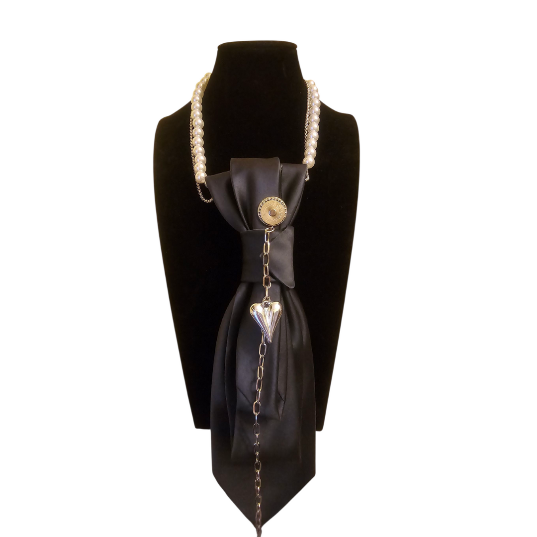 Cravatta Gioiello Midnight Heart di Claudia De Rosa Jewelry – collana-cravatta nera con catena e perle, charm argentato a cuore e fermaglio magnetico intercambiabile.
