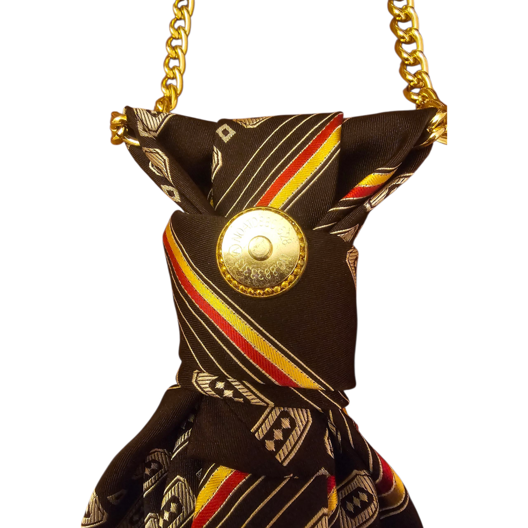 Dettaglio nodo Collana Cravatta Vintage Brown con spilla dorata
Alt Description:
Primo piano del nodo della Collana Cravatta Vintage Brown con orecchino a clip dorato riutilizzato come spilla e aggancio per Clap Calamita.