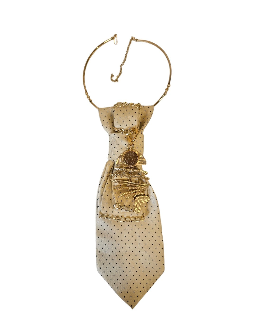 Flat lay cravatta gioiello Sandy Beach con pendente Nereide, collarino rigido e clasp magnetica su fondo neutro ispirato ai toni sabbia